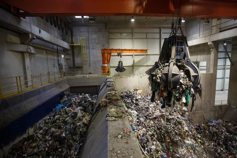 giant claw moving trash at waste to energy disposal plant