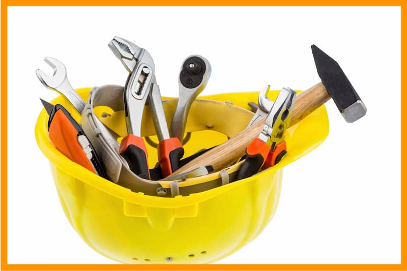 yellow hardhat with tools needed to demo bathroom safely