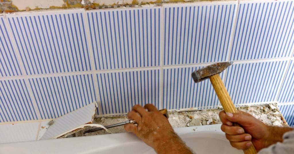 bathroom is renvoviert a person holding a small hammer doing a demo fixing the sink of the bathroom safely and efficiently