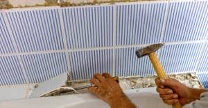 a person holding a small hammer doing a demo fixing the sink of the bathroom safely and efficiently
