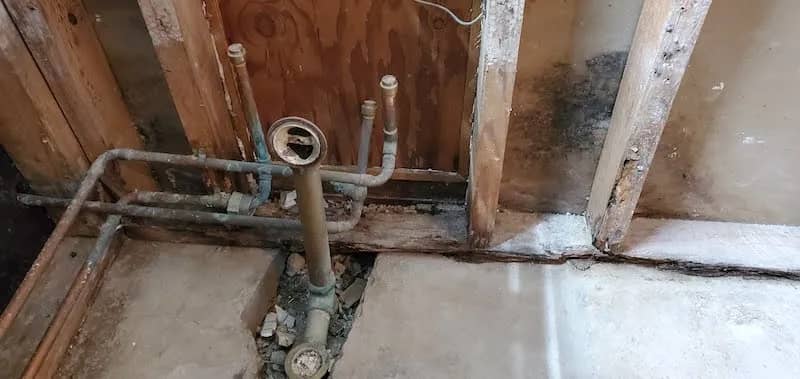 shower demolition complete with just old pipes and sewer lines remaining