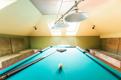 Entertainment room in the house in the attic with a billiard table