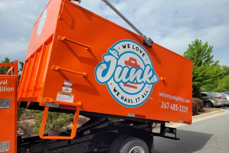 We Love Junk truck for hauling and other junk removal services parked beside the road