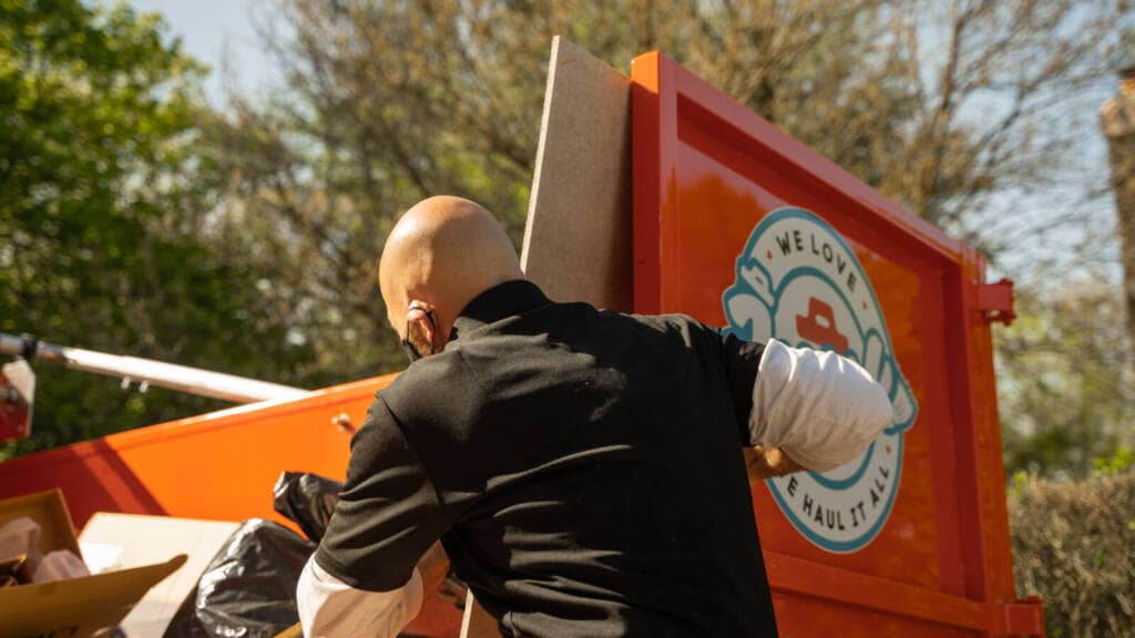 We Love Junk professional standing beside service truck