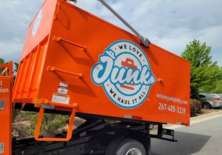 We Love Junk truck for hauling and other junk removal services parked beside the road